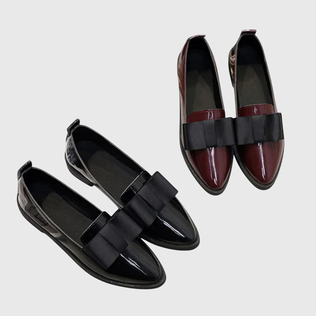 Top view of women's pointed toe loafers showing glossy patent finish and bow placement