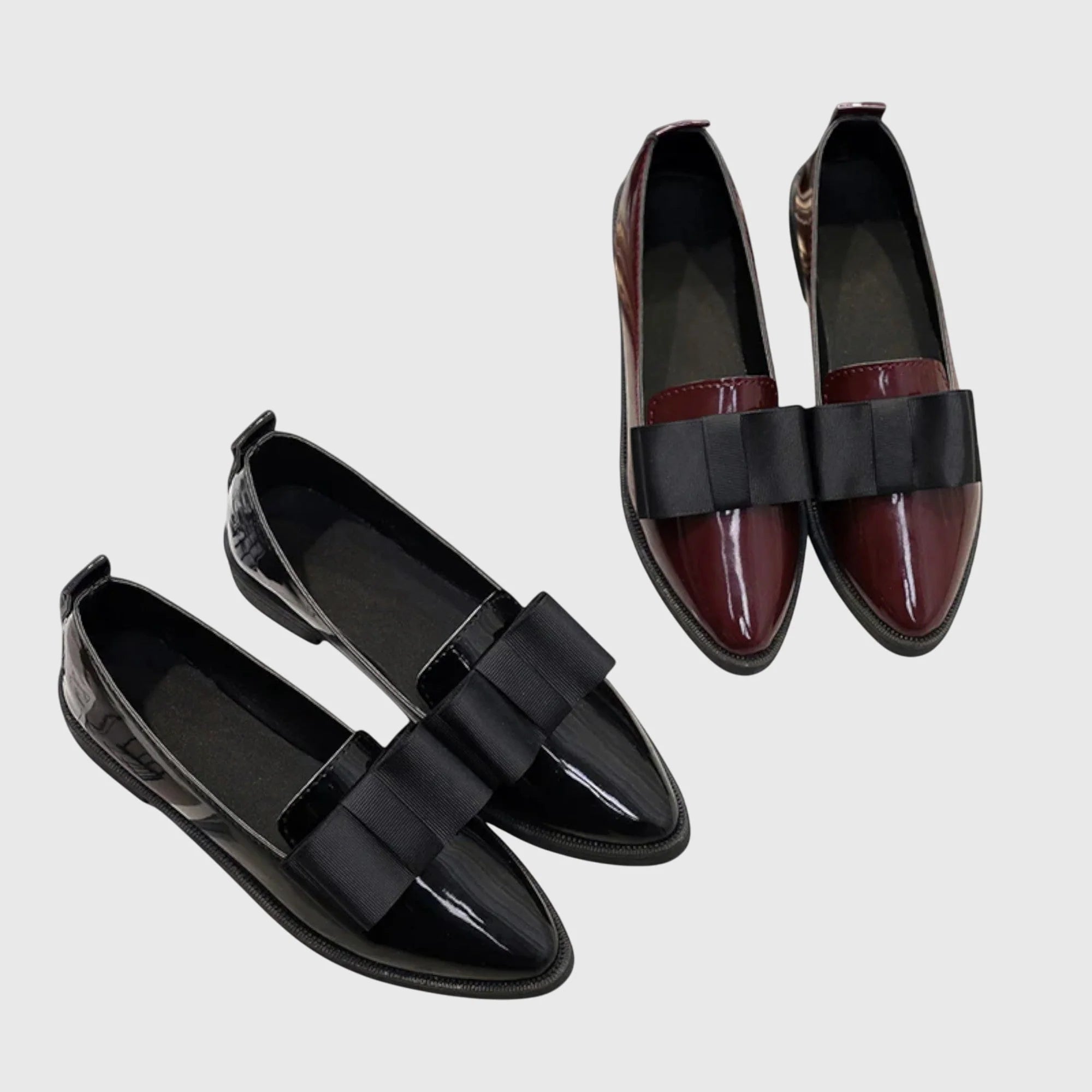 Top view of women's pointed toe loafers showing glossy patent finish and bow placement