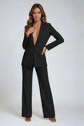 Woman wearing a black tailored blazer and straight-leg trousers co-ord set with notch lapels and single-button closure