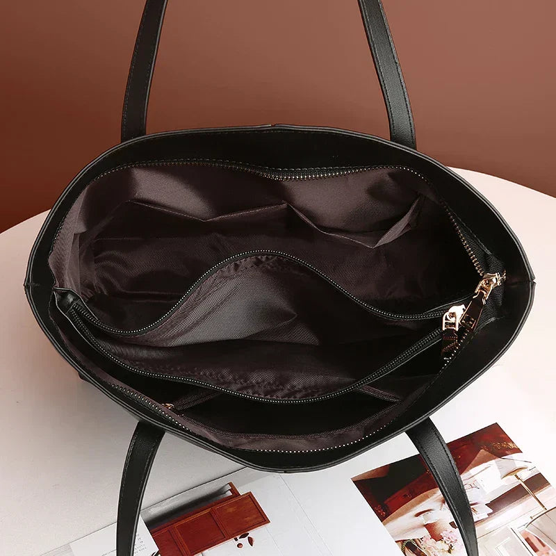 Black tote bag showing structured base and smooth finish, side angle view