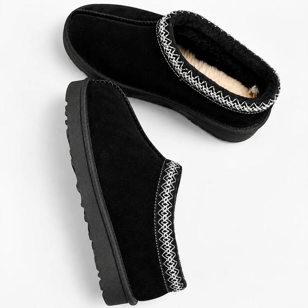 Detail of women's fleece lined slippers with decorative trim and slip-on construction