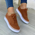Women's platform trainers with brogue detailing and lace-up closure worn with skinny jeans