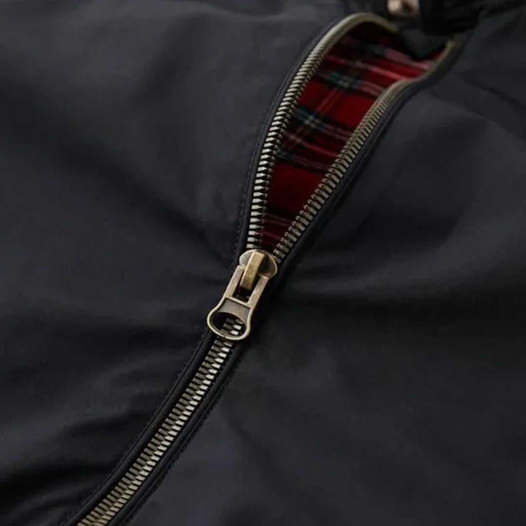 Side view of men's navy Harrington jacket with ribbed cuffs and tartan-lined interior visible