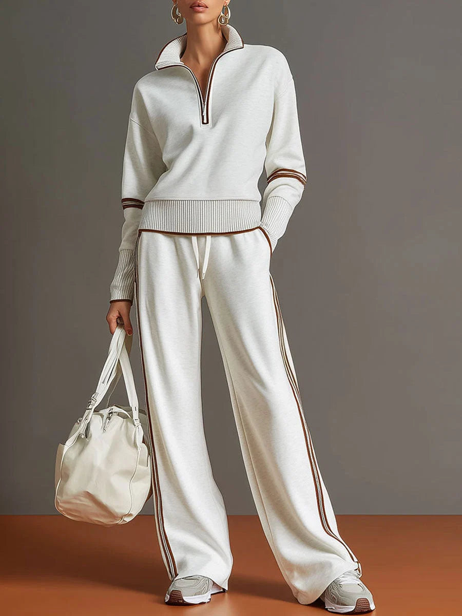 Woman wearing cream half-zip tracksuit set with retro stripe detailing and wide leg trousers
