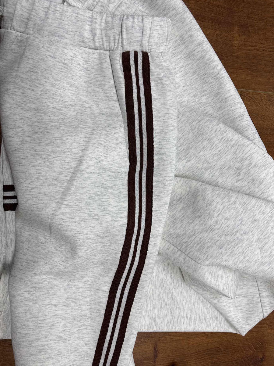 Woman in cream half-zip tracksuit set showing coordinated two-piece styling for casual wear