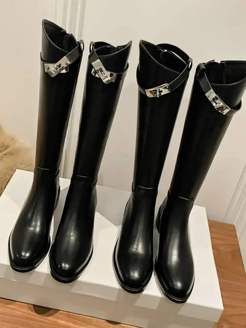 Side view of knee high boots showing smooth finish and low block heel construction