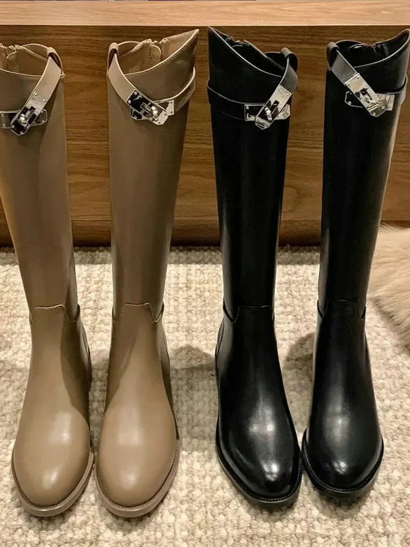 Women's knee high boots displayed showing shaft height and block heel design