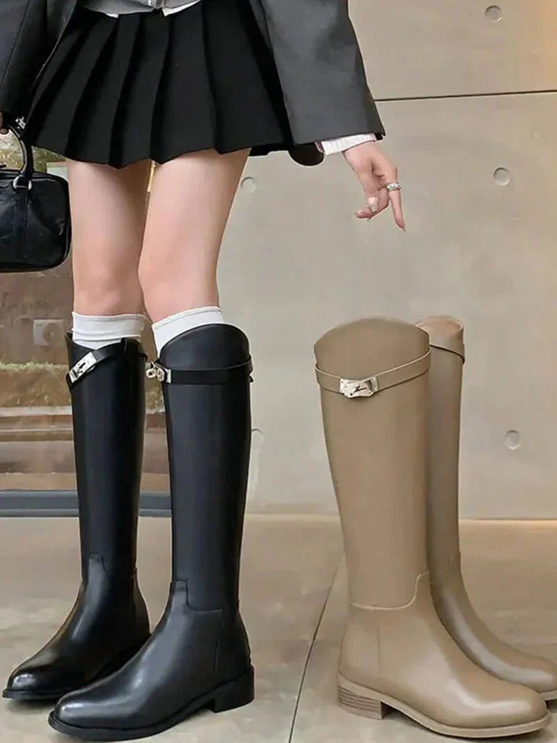 Knee high boots in black featuring structured fit and decorative metal hardware detail