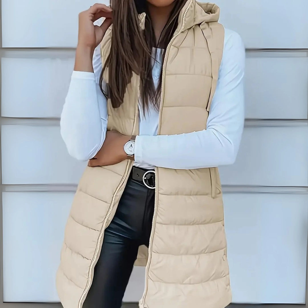 Side angle of women's long puffer gilet displaying extended length and relaxed fit through hips