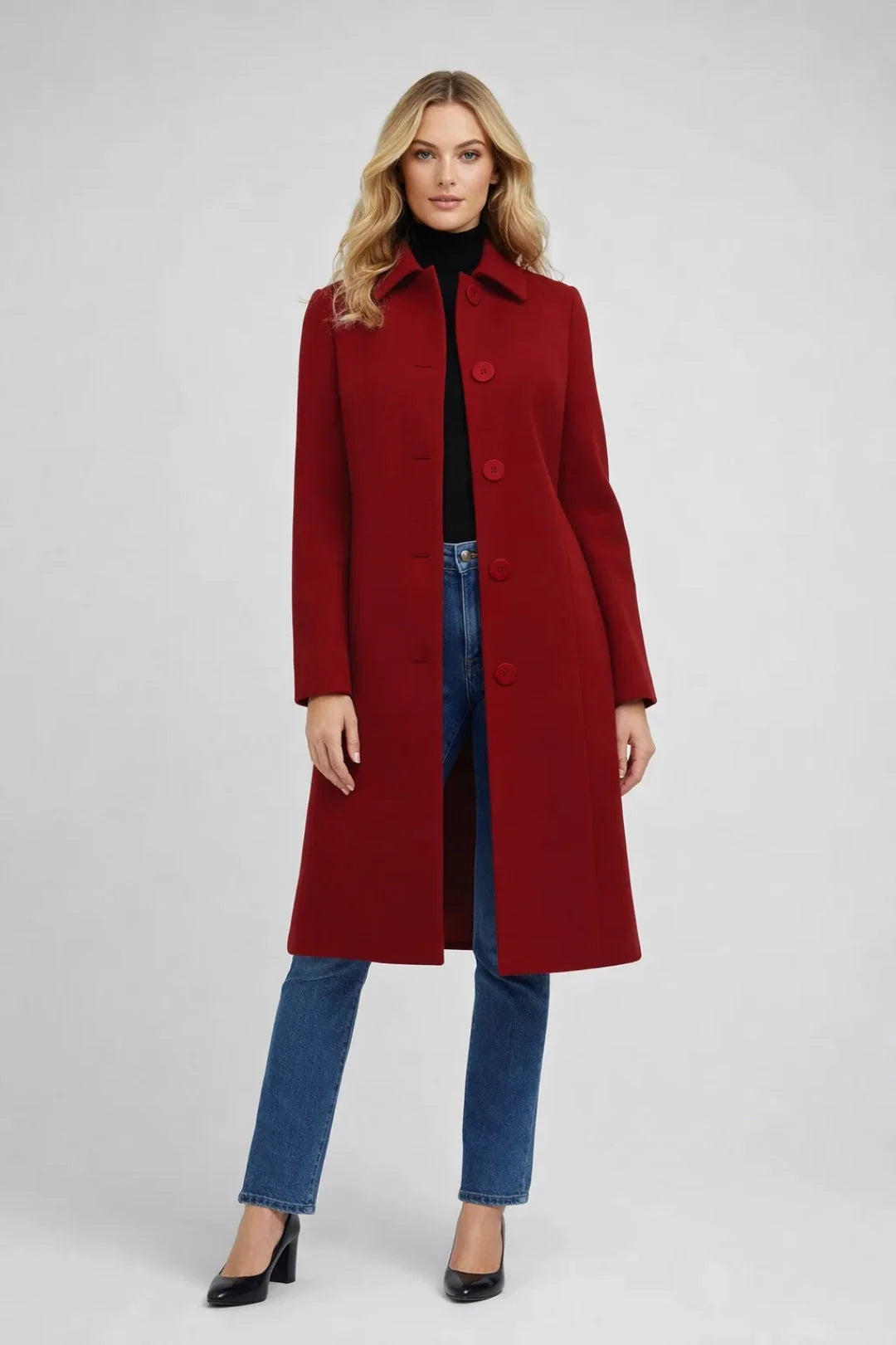 Women's long wool-blend coat in deep red with notched collar and button-front closure, styled over black turtleneck and jeans