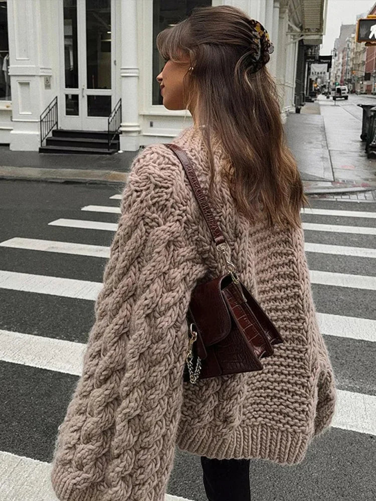 Close-up of oversized cable knit jumper showing chunky textured knit and relaxed sleeve detail