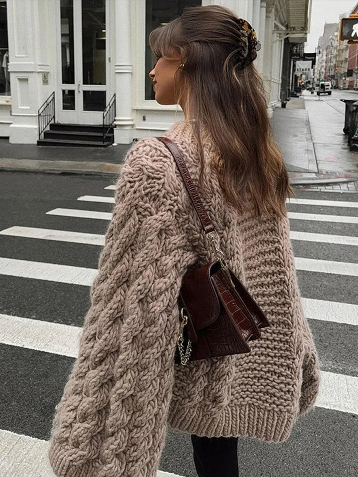 Close-up of oversized cable knit jumper showing chunky textured knit and relaxed sleeve detail