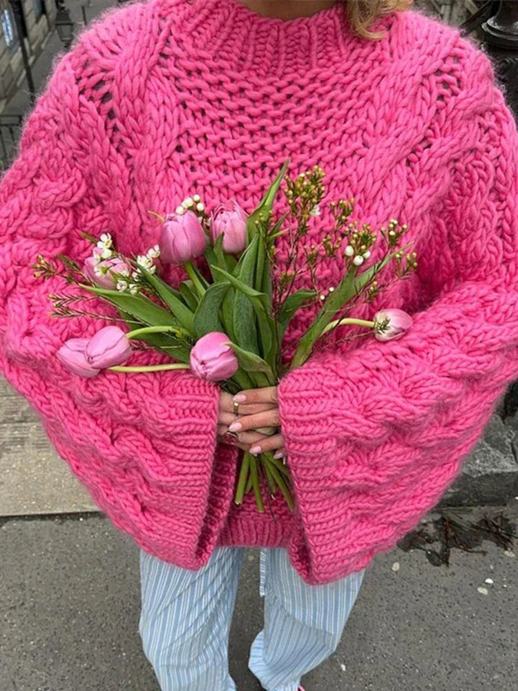 Detail of chunky cable knit pattern and ribbed cuffs on oversized women's jumper