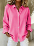Women's oversized shirt in vibrant pink with classic collar and button-through front, styled with white trousers