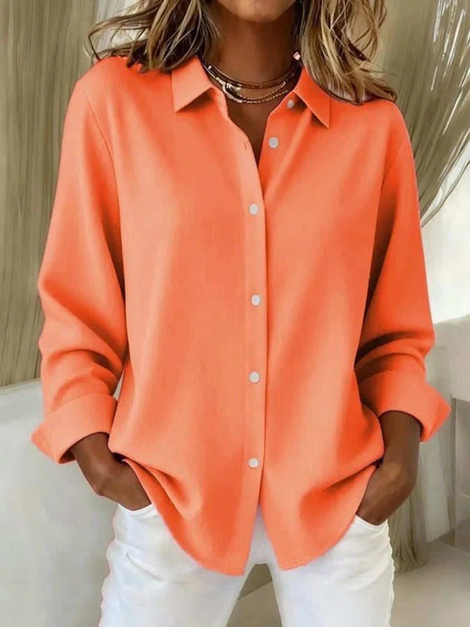 Women's oversized shirt with pointed collar and roll-up cuffs, worn loose over white trousers for casual styling