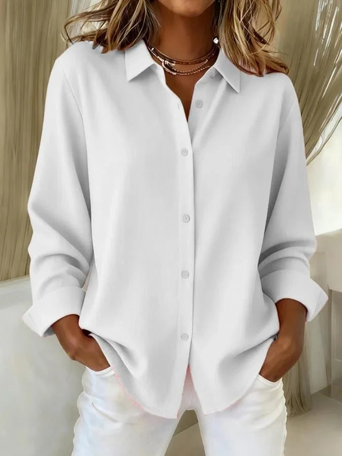 Detail of women's oversized shirt button placket and collar showing polished finish and structured shape