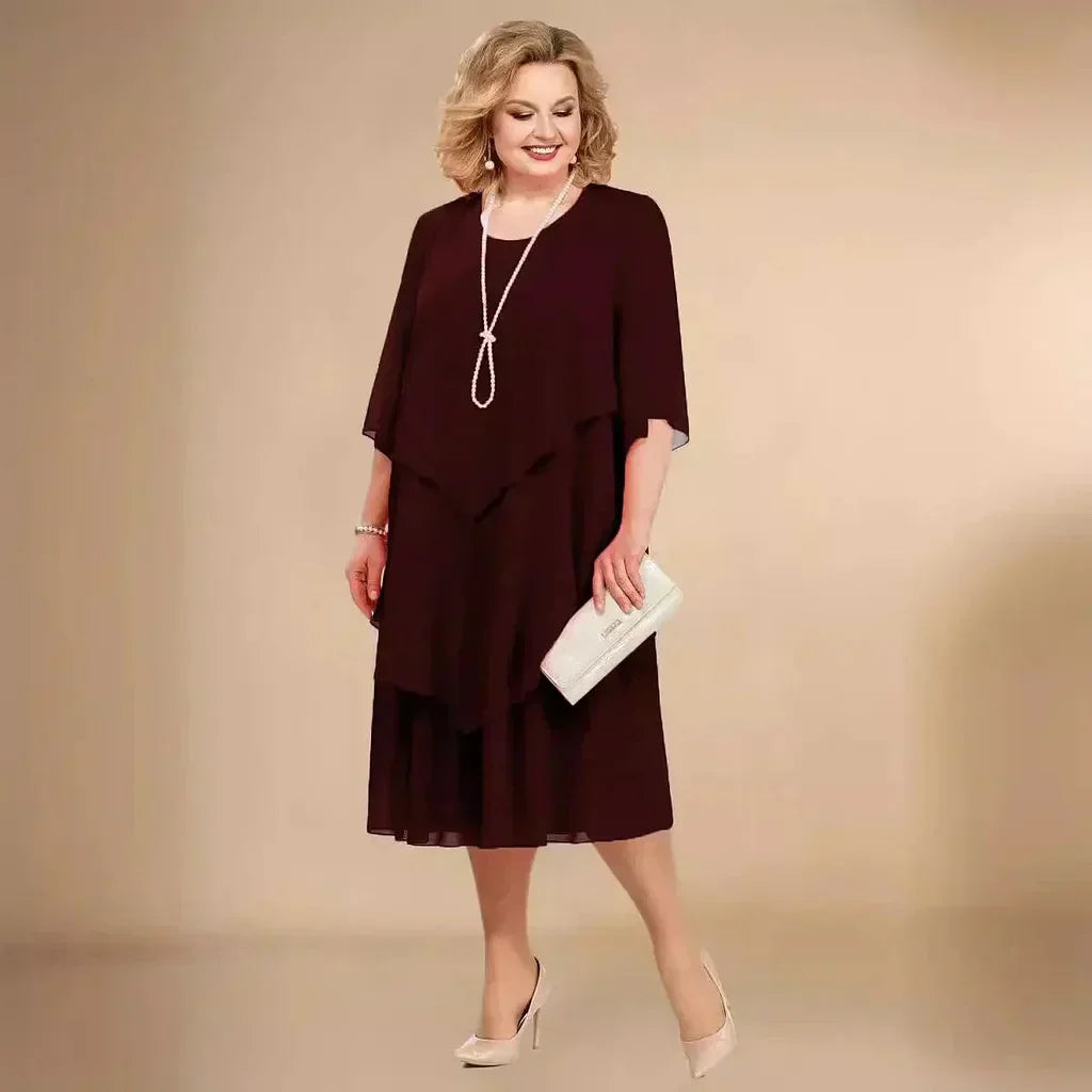 Back view of layered midi dress showing flowing overlay and structured under-layer for occasion dressing
