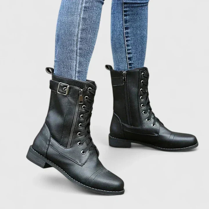 Women's combat boots in black with lace-up front and side zip worn with denim jeans