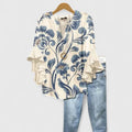 Women's floral print blouse in cream with blue scrolling motif and ruffled sleeves styled with denim