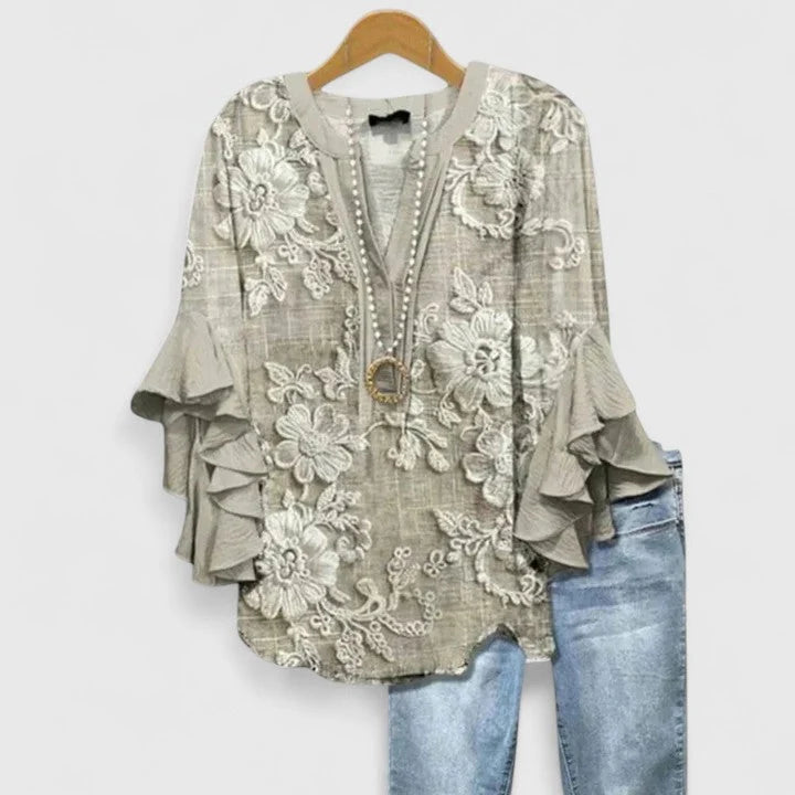 Close-up of floral print blouse showing V-neckline and button-front closure detail