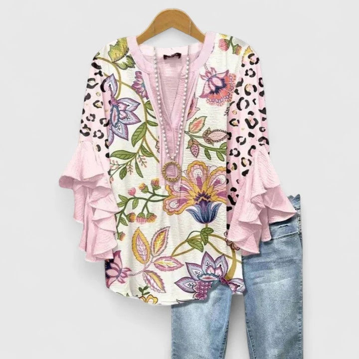 Front view of V-neck blouse with button closure and floral motif