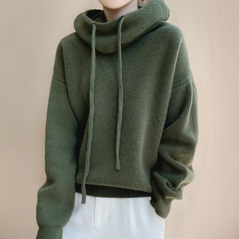 Detail shot of women's hooded knit jumper featuring adjustable drawstring hood and relaxed shoulders