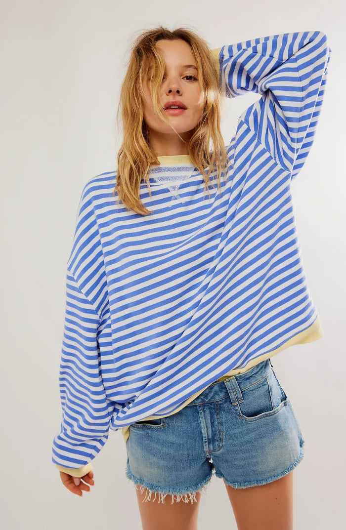 Side view of women's oversized striped jumper with drop shoulders and contrast neon cuffs