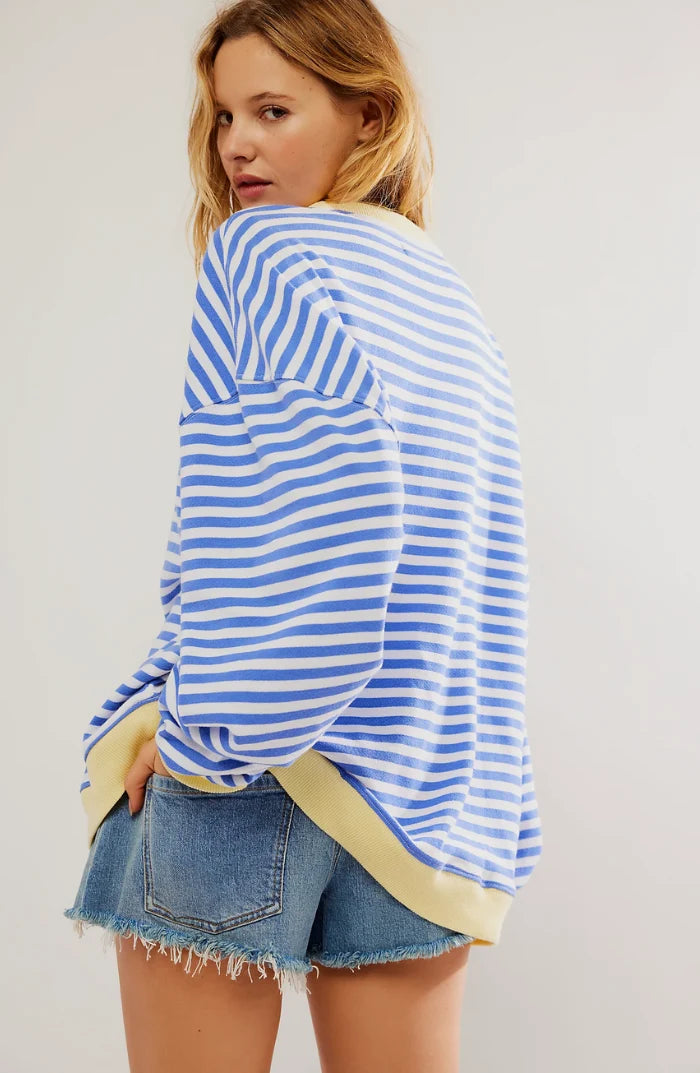Detail shot of contrast neon trim at cuffs and hem on oversized striped jumper