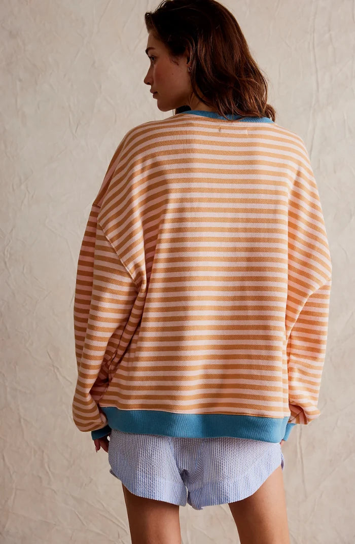Close-up of knit fabric texture on oversized striped jumper showing smooth finish