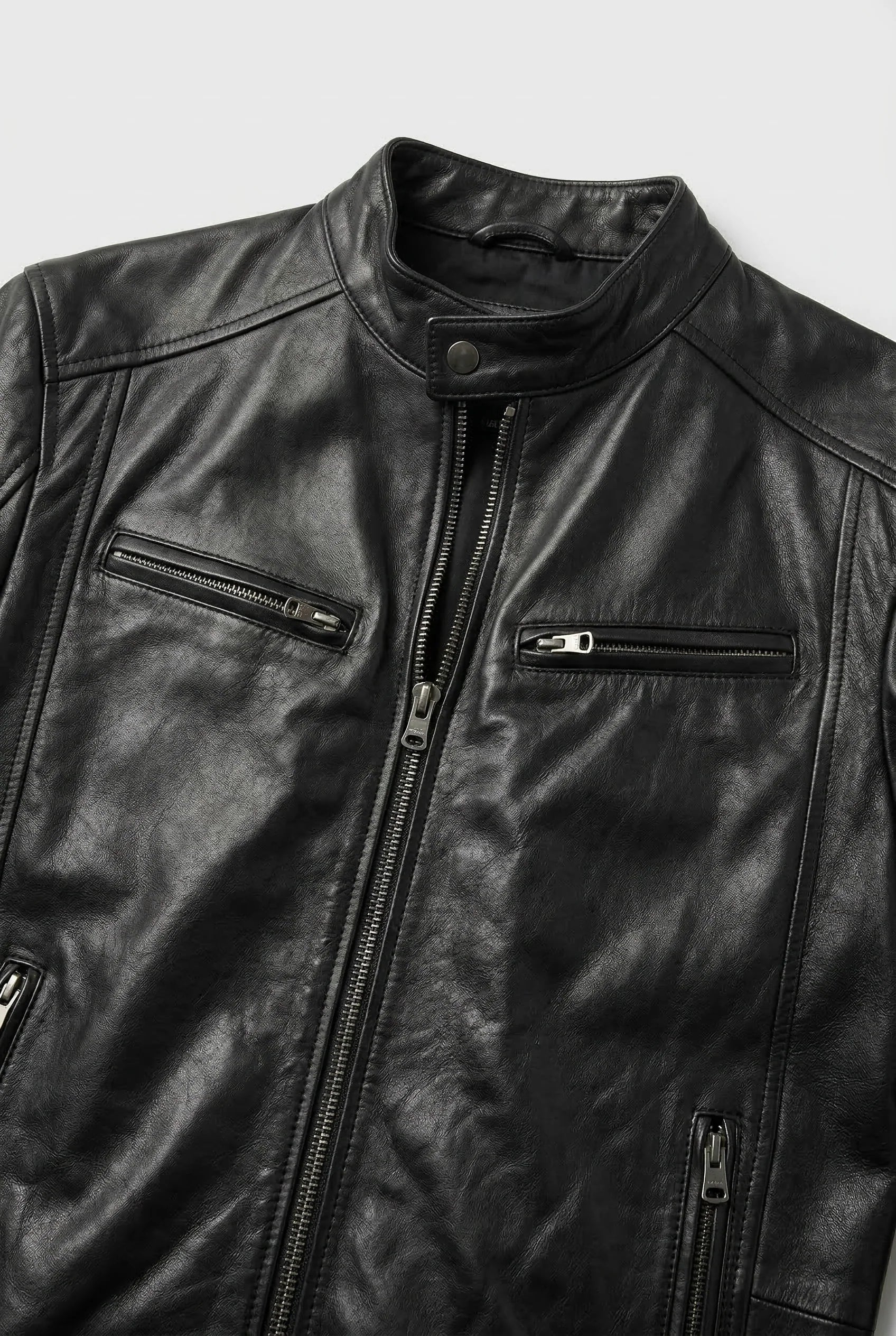 Close-up of men's biker jacket zip pocket detailing and smooth faux leather finish