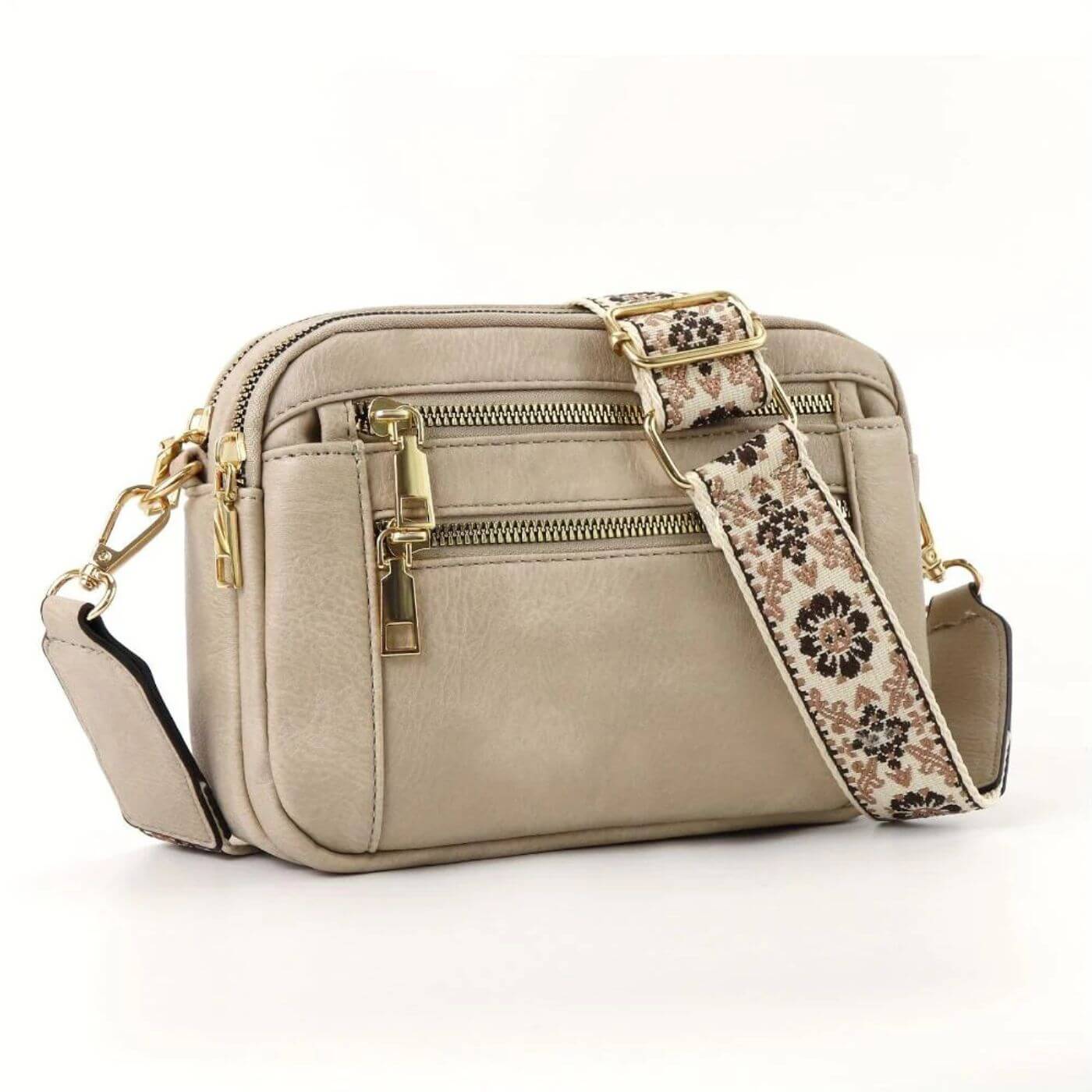 Detail shot of gold zip pulls and clasp hardware on structured crossbody bag