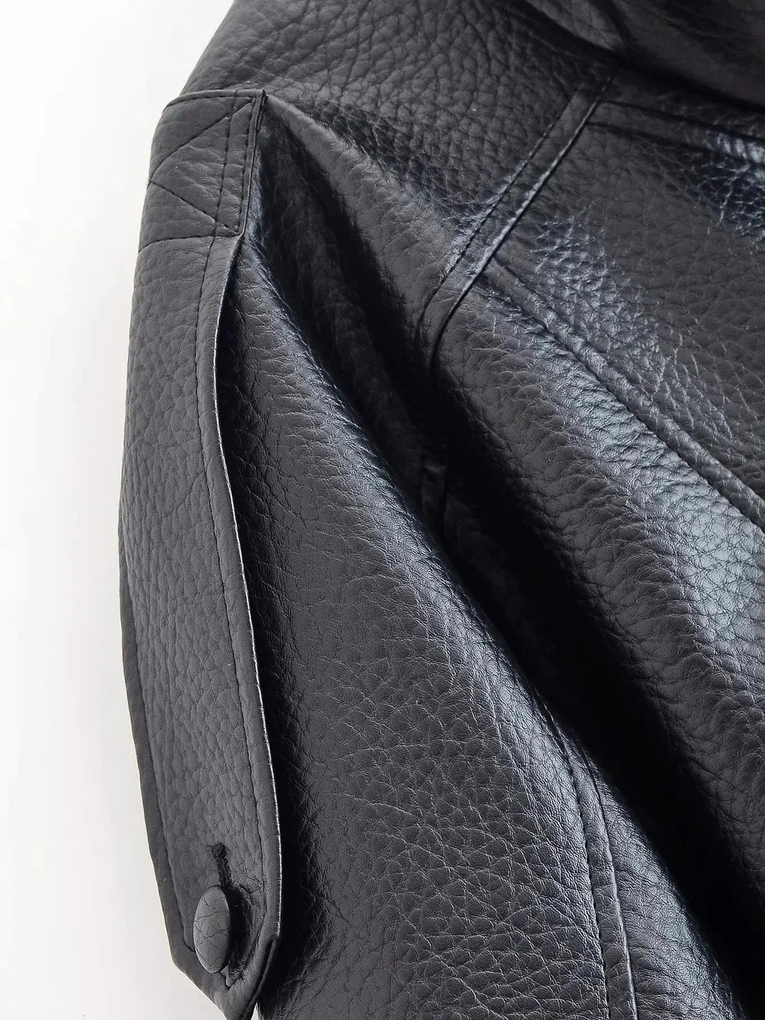 Detail of elasticated hem and cropped length on women's bomber jacket