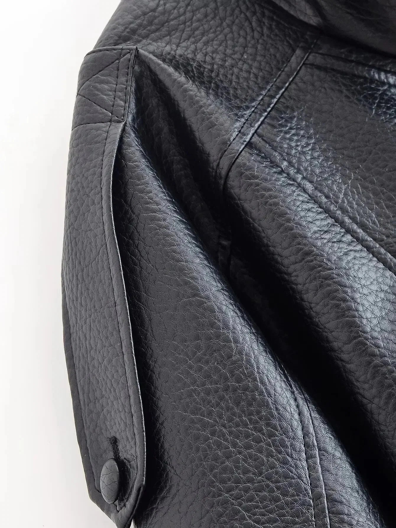 Detail of elasticated hem and cropped length on women's bomber jacket