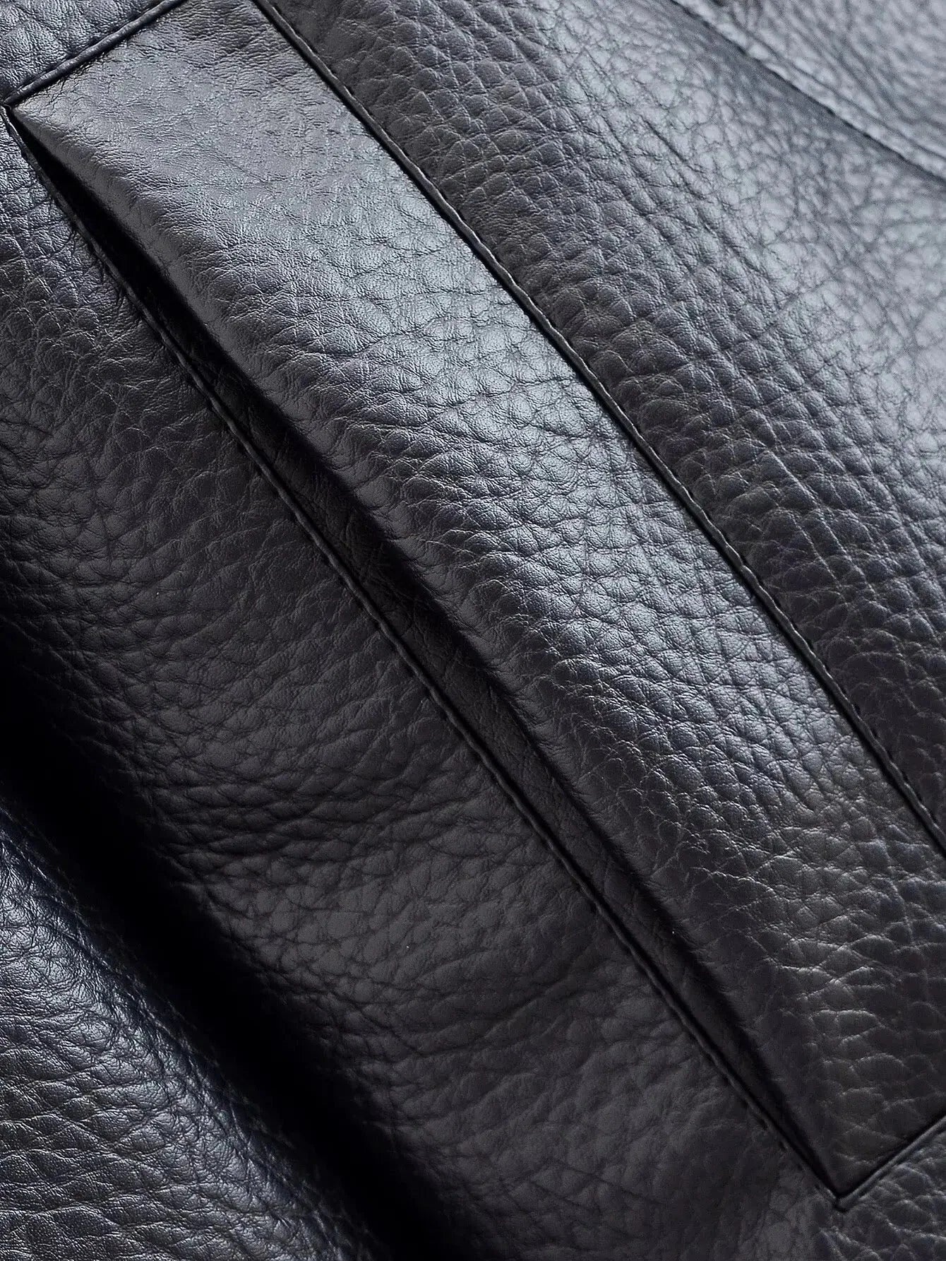 Close-up of zip fastening and practical details on women's faux leather jacket