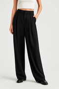 Women's wide leg trousers in black with high waist and pleated front detail worn with white crop top