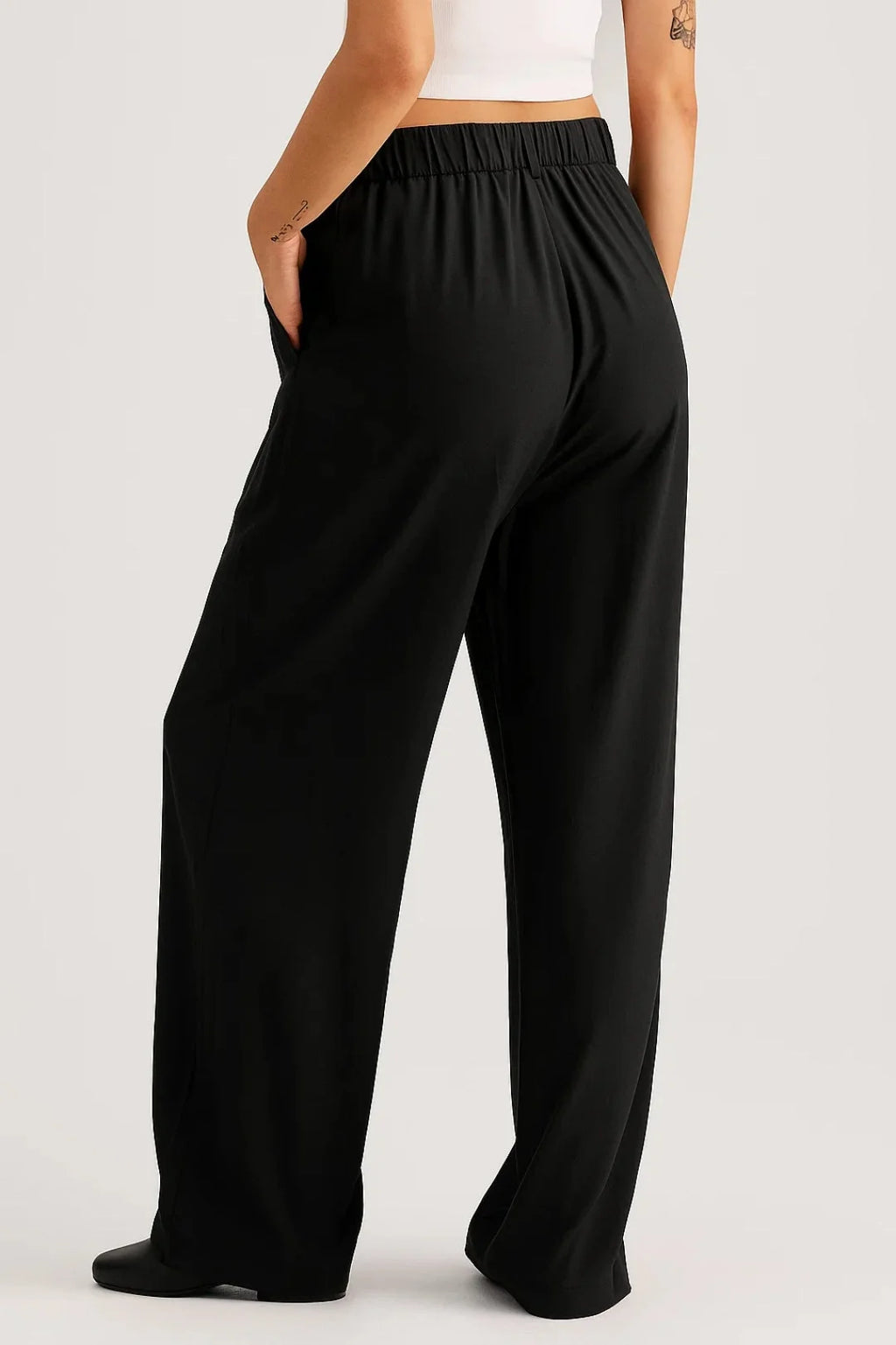 Close-up view of women's wide leg trousers showing high waist band and pleated design detail