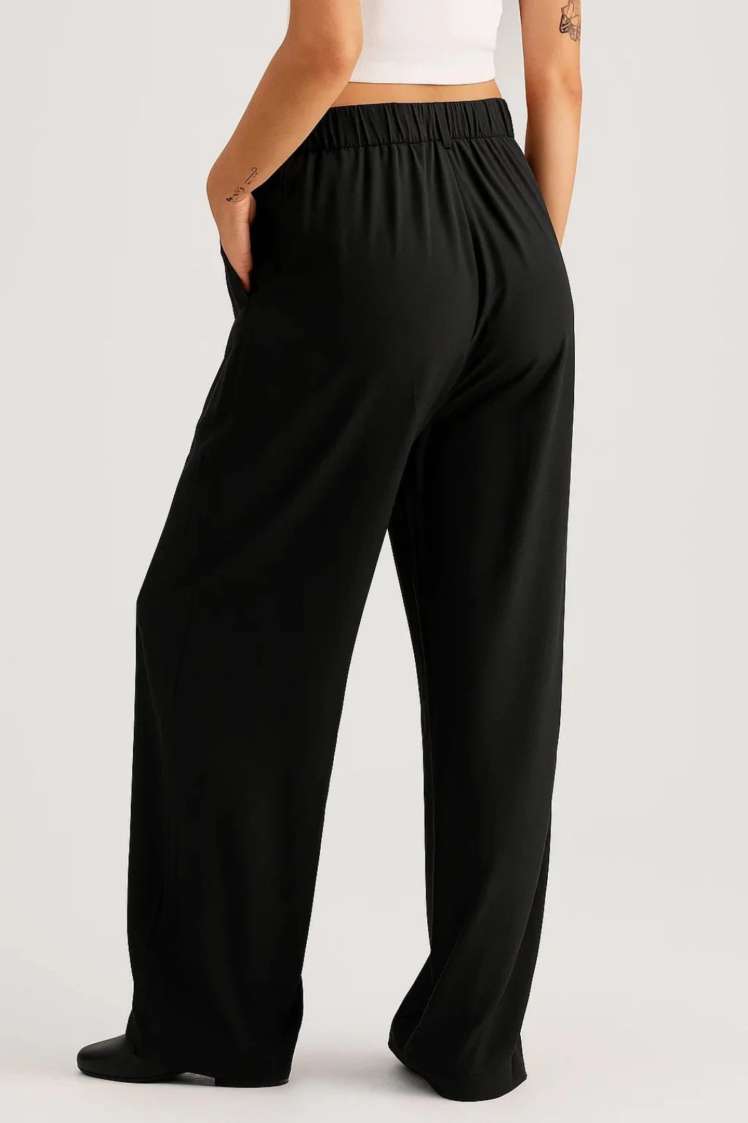 Close-up view of women's wide leg trousers showing high waist band and pleated design detail