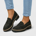Women's chunky loafers in black with deep tread sole and penny strap detail worn with light blue jeans