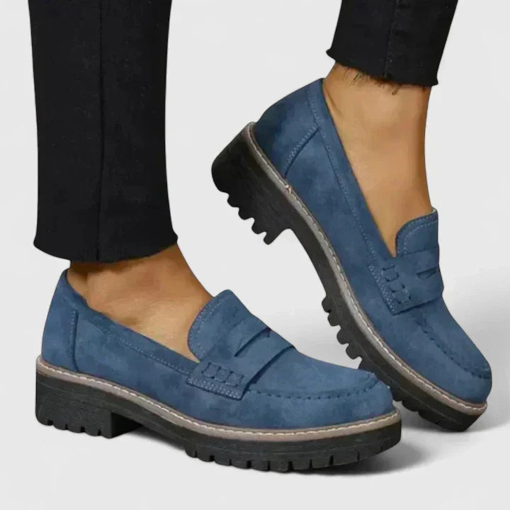 Side profile of women's chunky loafers displaying low block heel and slip-on construction with penny strap