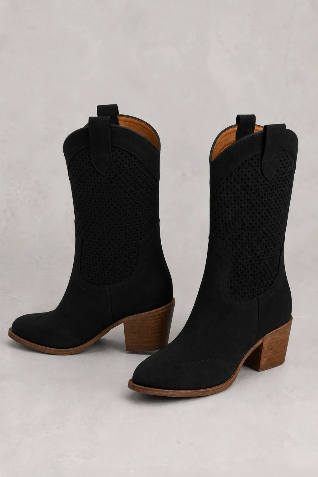 Three-quarter view of women's white cowboy boots with pointed toe and Western stitching