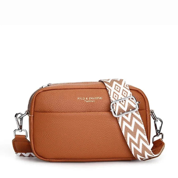 Compact camera-style crossbody bag with adjustable wide strap featuring diamond geometric pattern