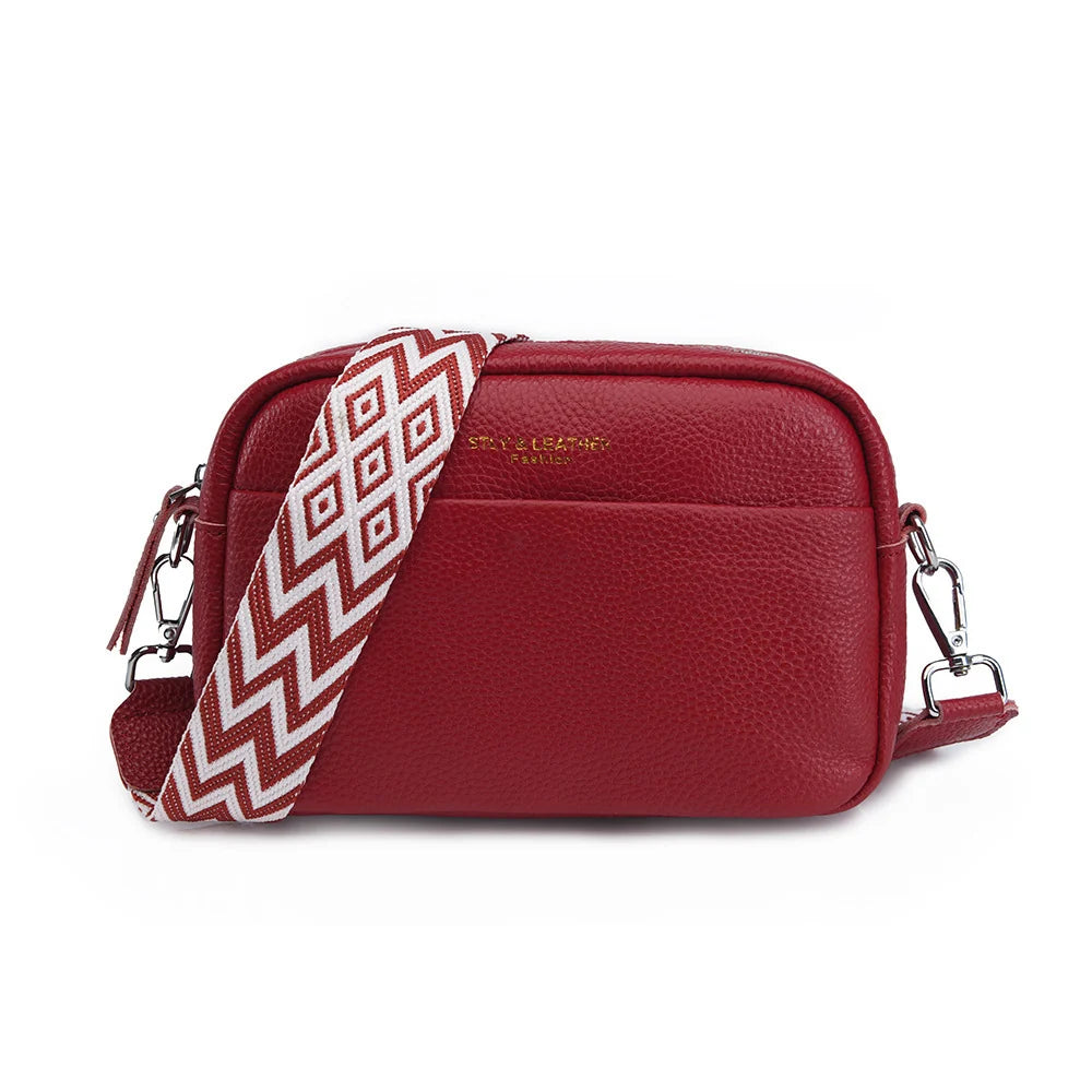 Teal pebbled crossbody bag with graphic geometric-print strap and silver zip-top closure
