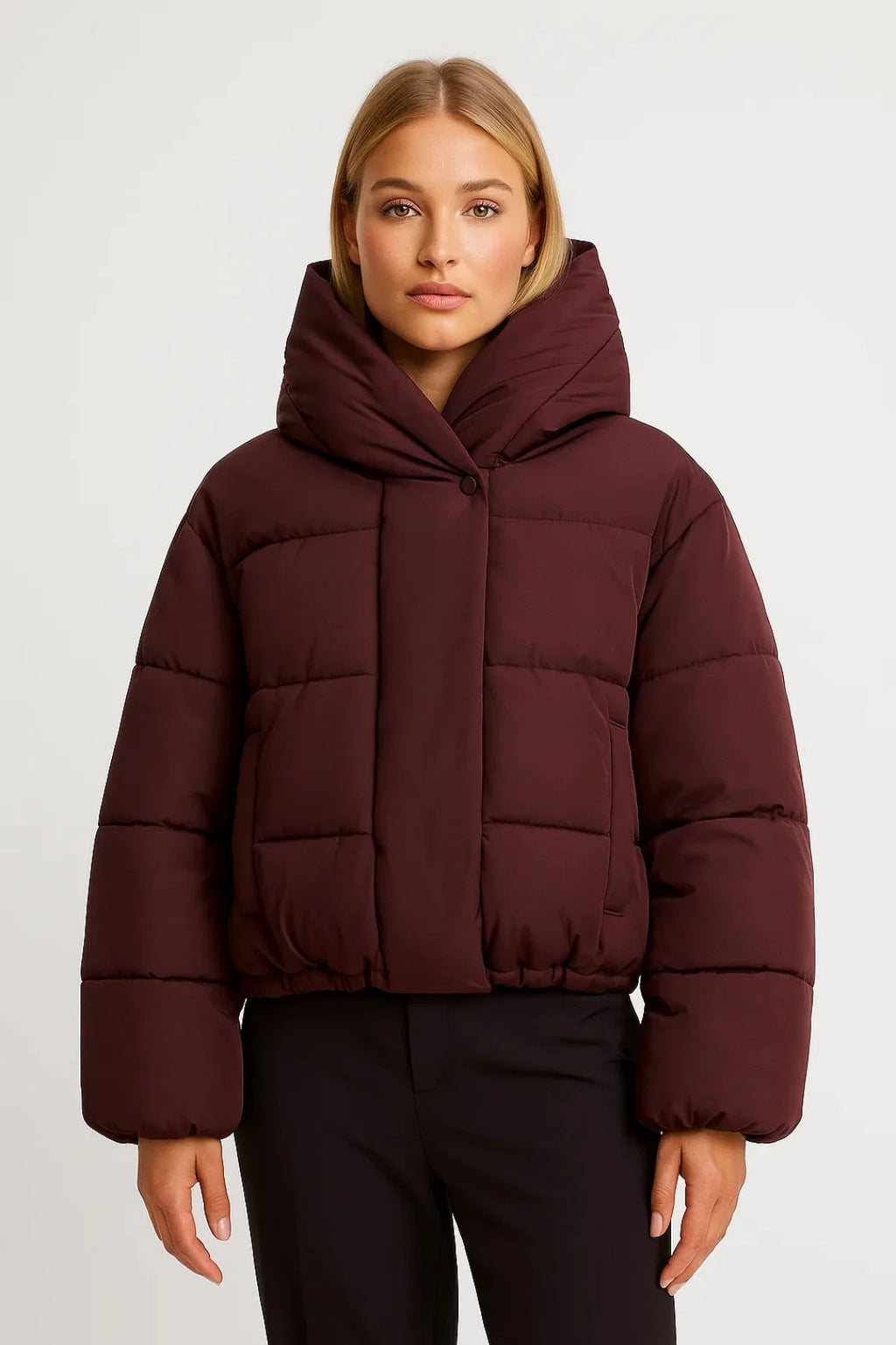 Close-up detail of oversized puffer jacket quilted construction and relaxed fit sleeves in burgundy tone