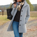 Woman wearing a grey women's tailored wool-blend coat with button-front closure and structured collar outdoors