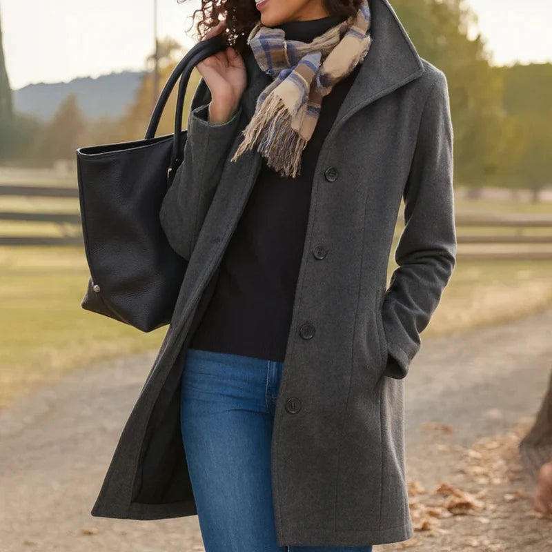 Side view of woman in grey women's tailored wool-blend coat with functional side pockets