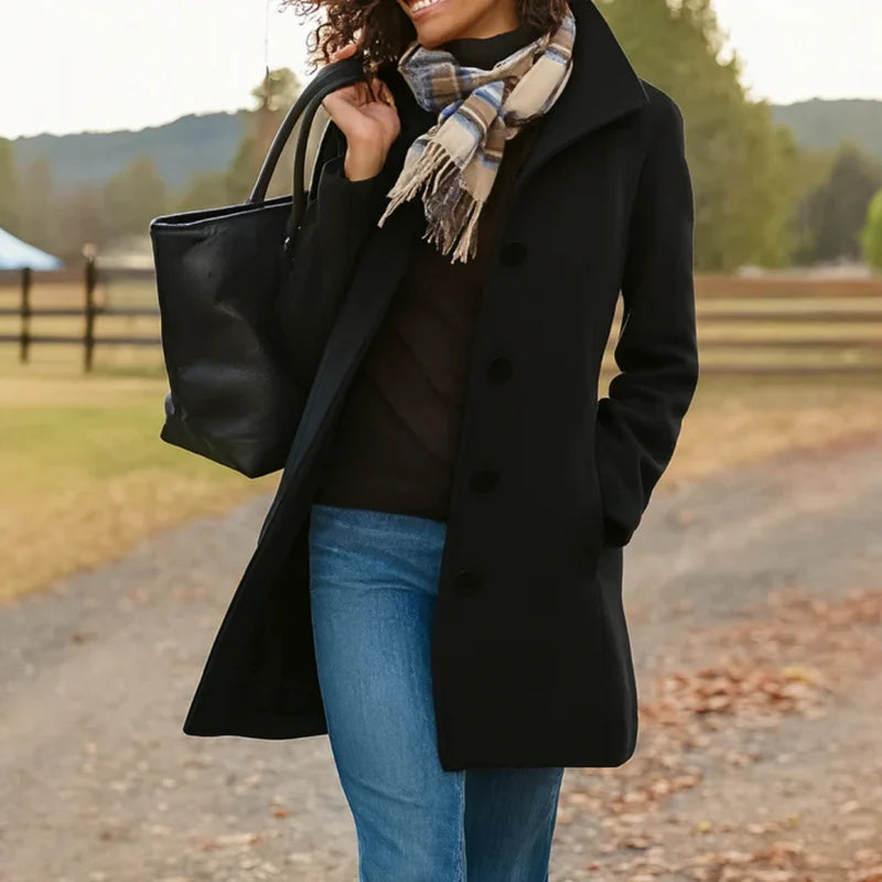 Woman styling grey women's tailored wool-blend coat over black top and blue jeans