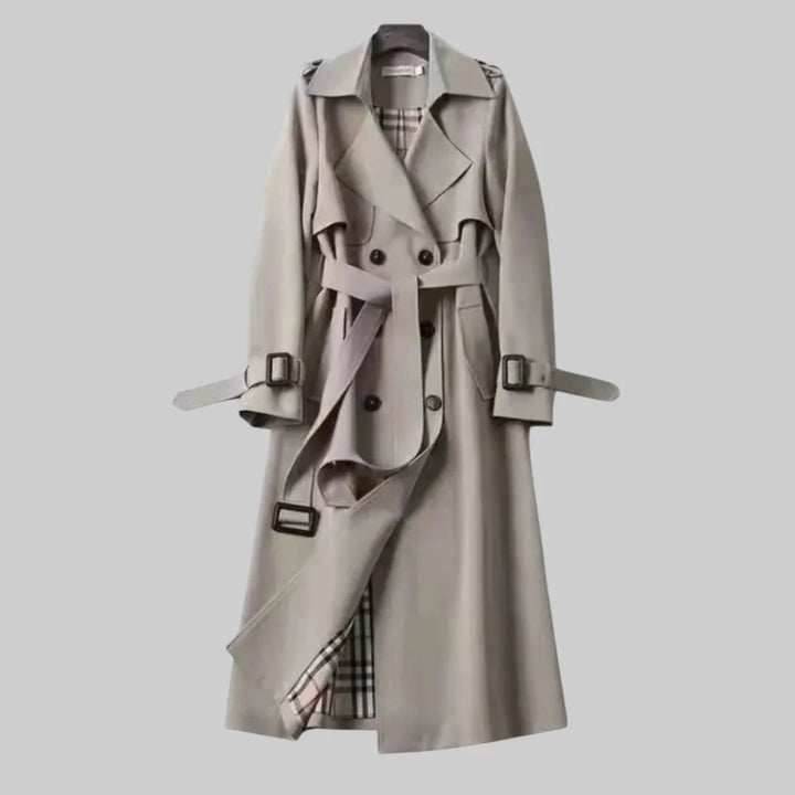 Women's trench coat belted at waist showing knee length silhouette and classic design