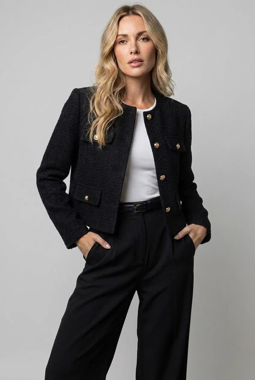 Close-up of tweed jacket showing textured fabric finish and gold-tone button detailing