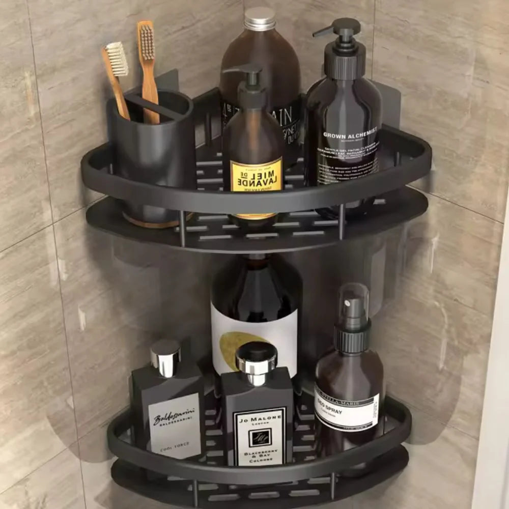 Matte black two-tier corner shelf organiser holding men's grooming bottles, toothbrushes, and bathroom essentials in a tiled shower space