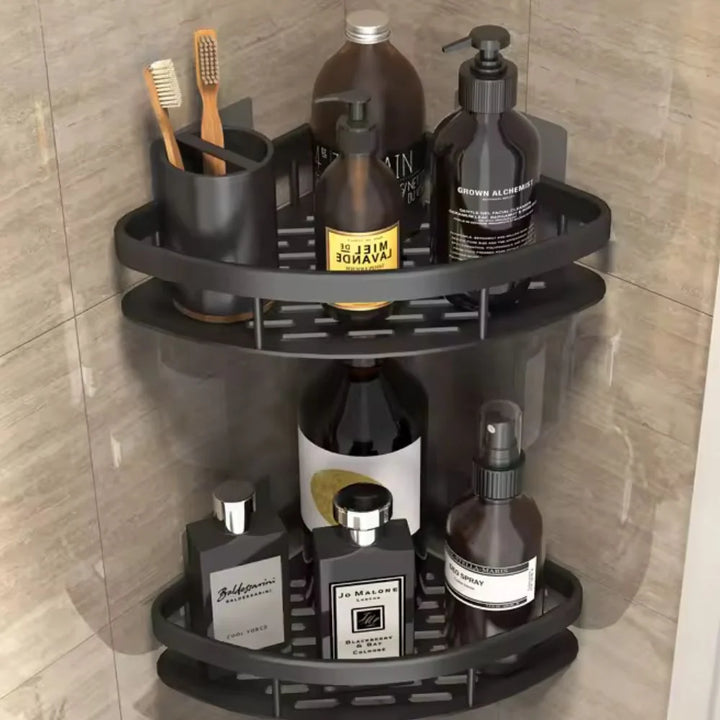Matte black two-tier corner shelf organiser holding men's grooming bottles, toothbrushes, and bathroom essentials in a tiled shower space